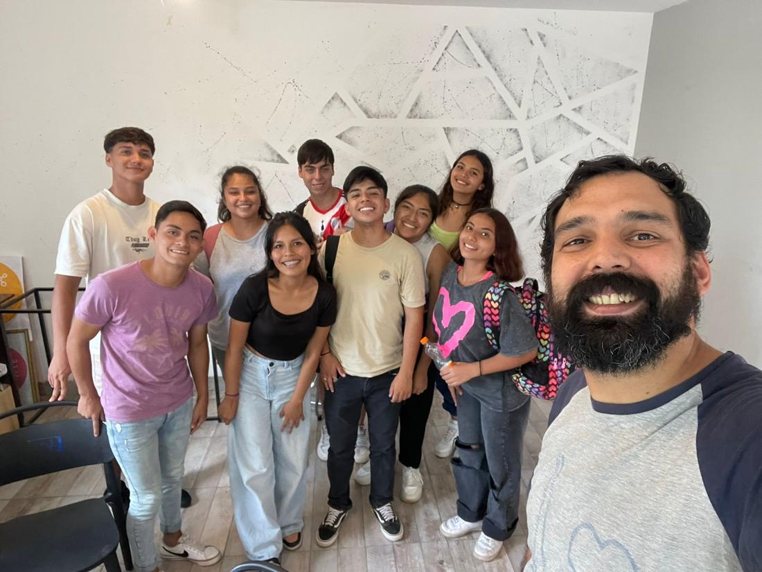 Estudiantes sonriendo junto al profesor